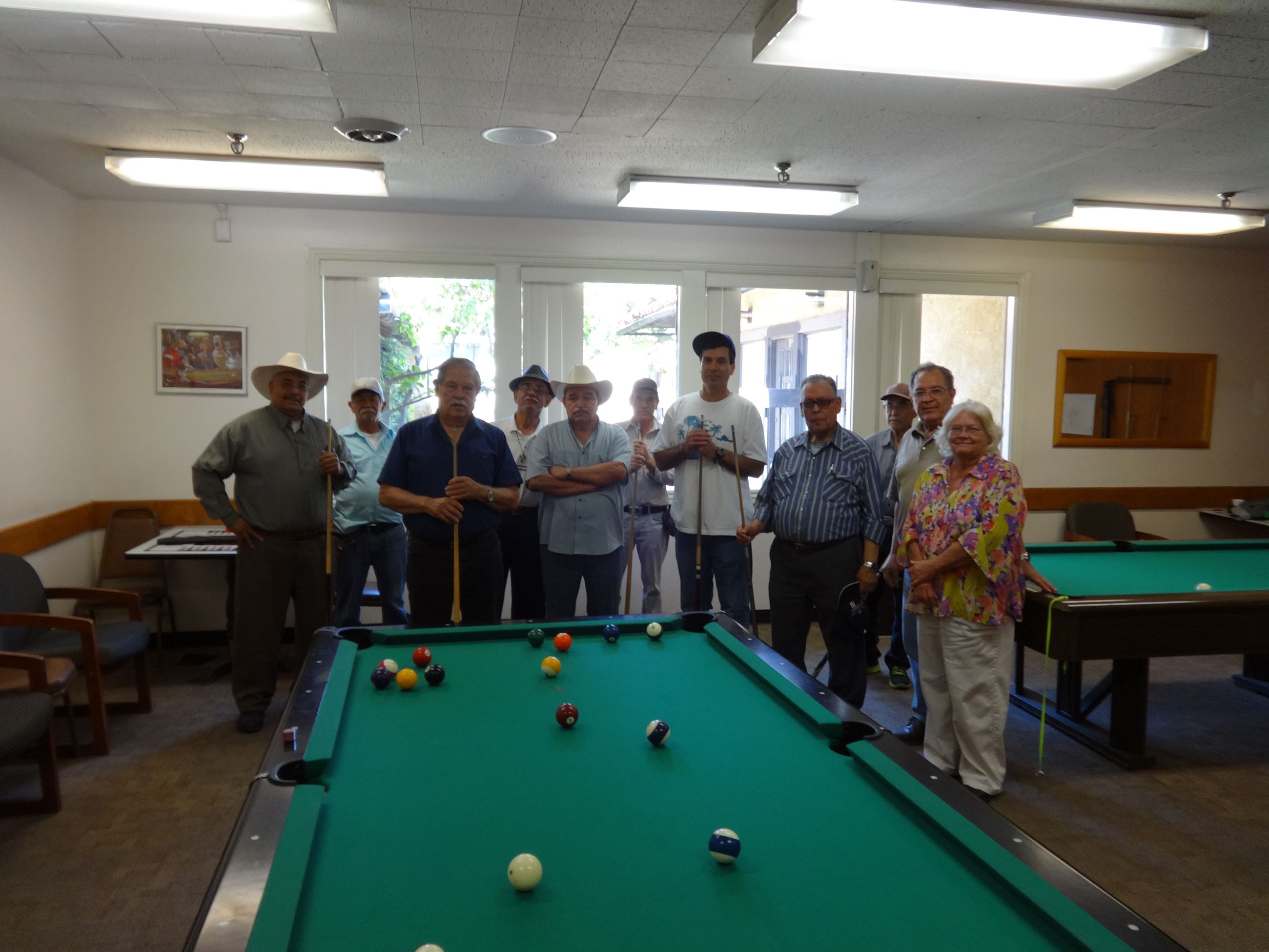 Group picture of older gentlemen by the billiards table